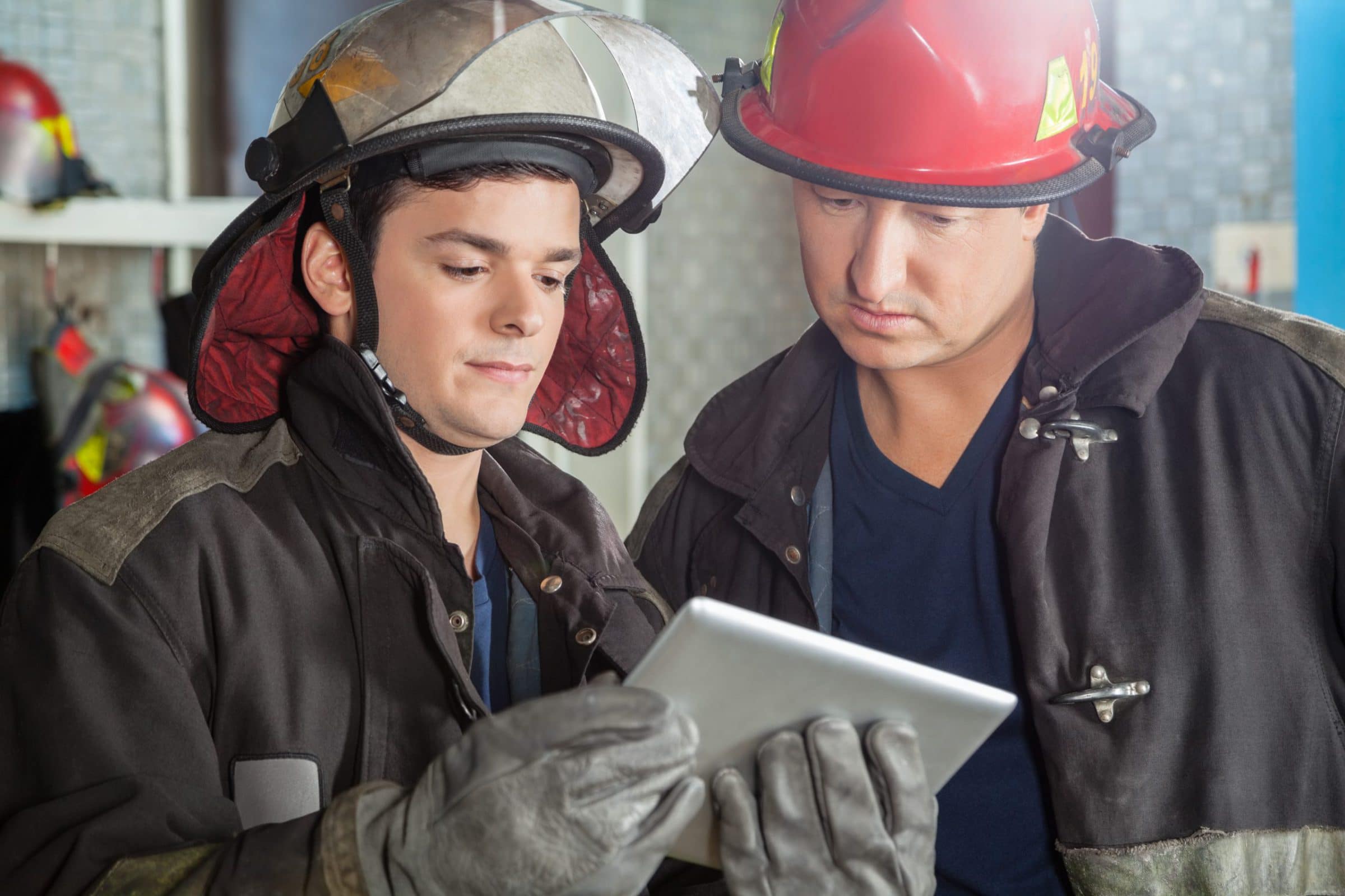 Two firefighters looking at a tablet